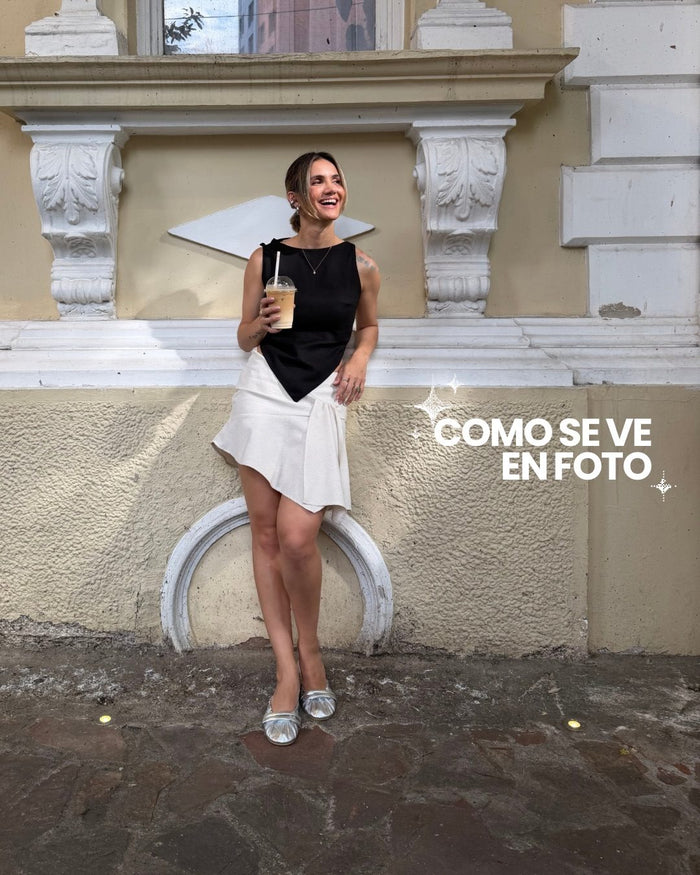 Clienta con blusa negra y falda arena asimétrica